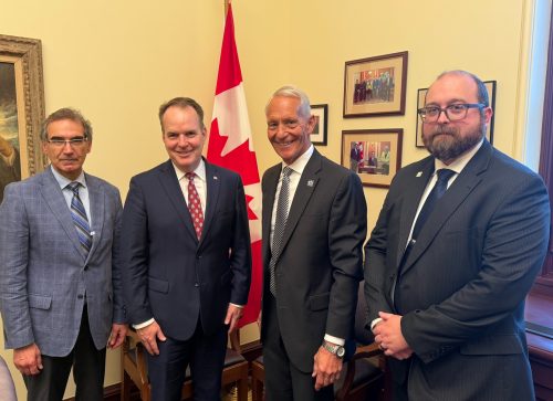 4 people in front of Canadian flag